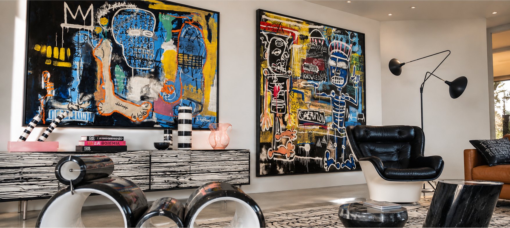 Two large expressive paintings in black, blue and yellow above a striped console in a bright modern living room