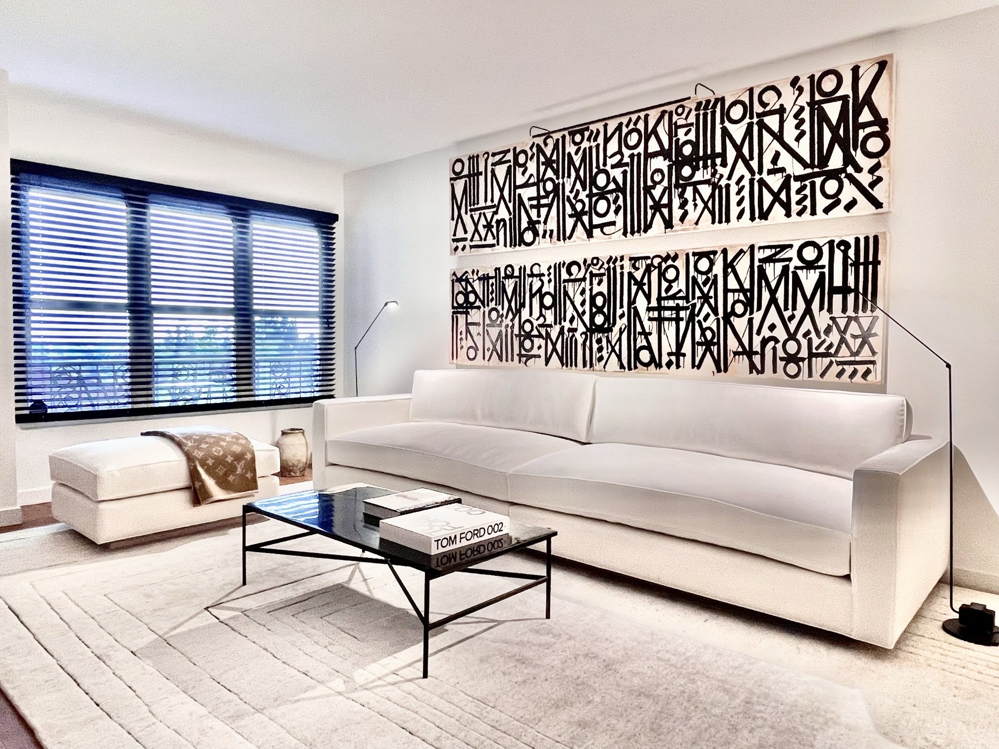 Two long black and white script panels above a white sofa