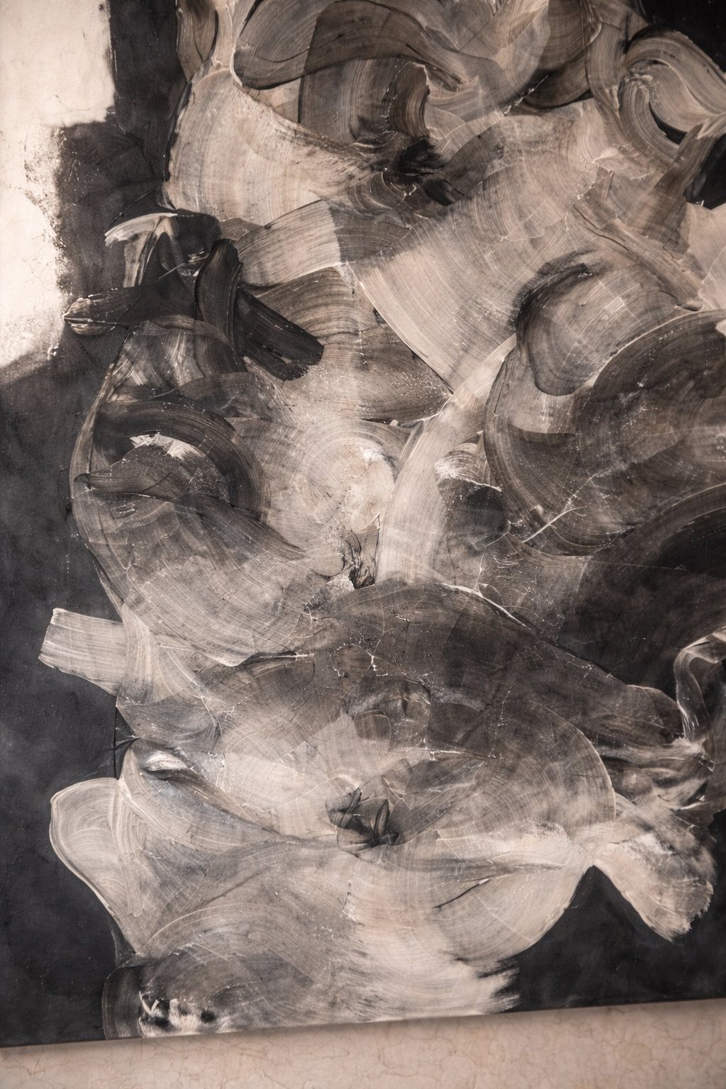 Close detail of layered grey and white brush strokes on a black ground